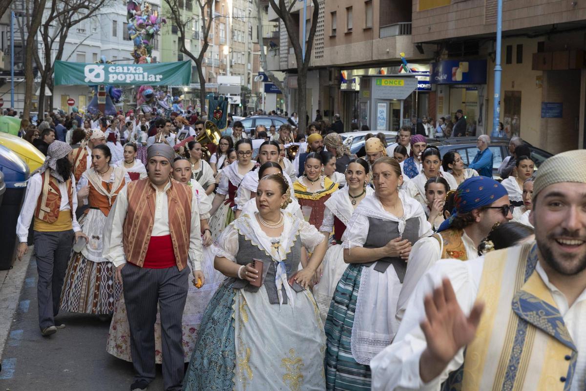 Falleros y falleras y, detrás, un grupo de músicos en el Recorregut Faller de Xàtiva.