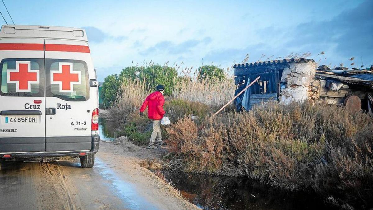 Un voluntario lleva comida a una infravivienda.