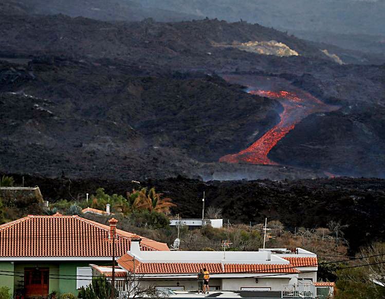 Dos personas, en una casa de Tajuya, observan la lava. | |