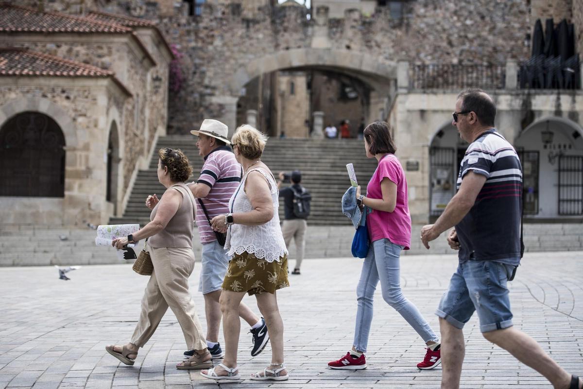 Turistas paseando por la plaza Mayor de Cáceres.