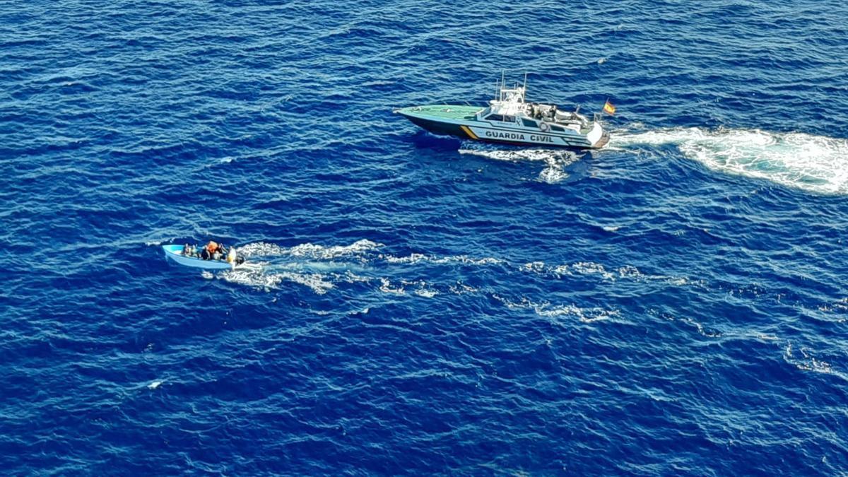 Ein Schiff der Guardia Civil kontrolliert ein Migrantenboot. (Archivbild)