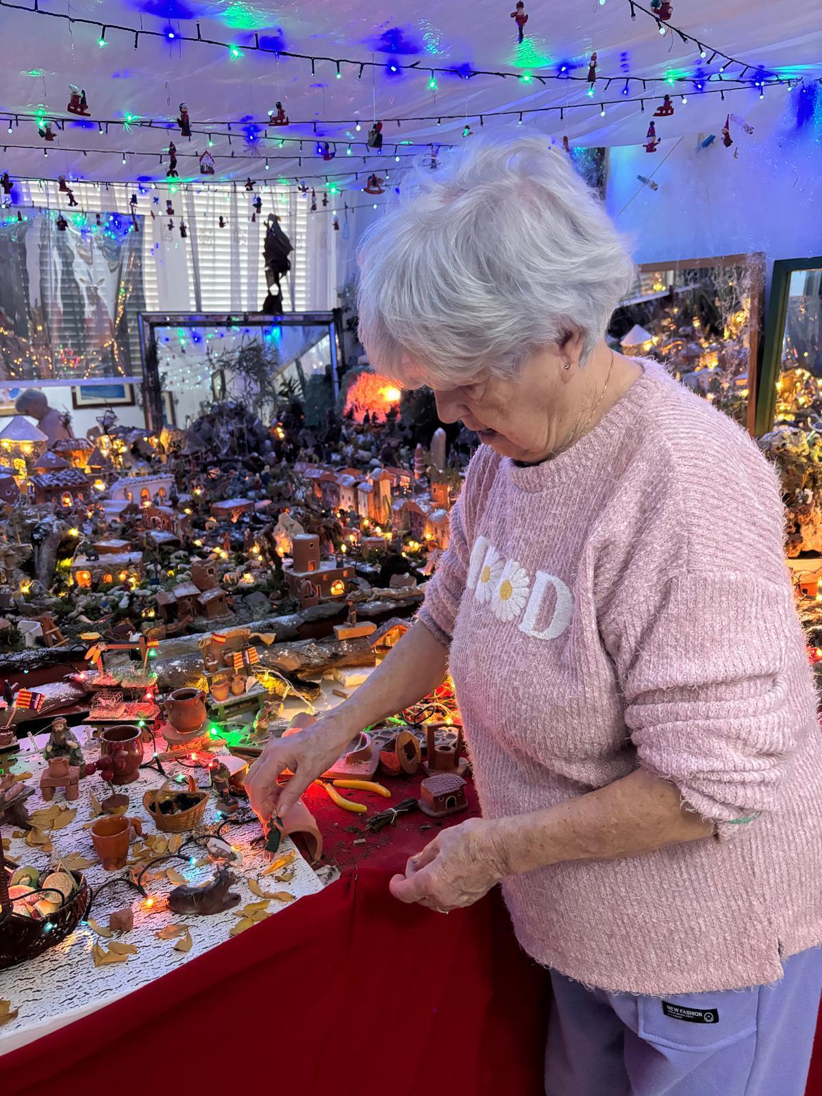 Catalina Maria coloca una figura en el belén gigante que monta todas las Navidades en su casa.