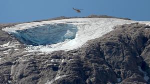 Un helicóptero sobrevuela la parte del glaciar que se ha desprendido en la montaña Marmolada, en Italia.