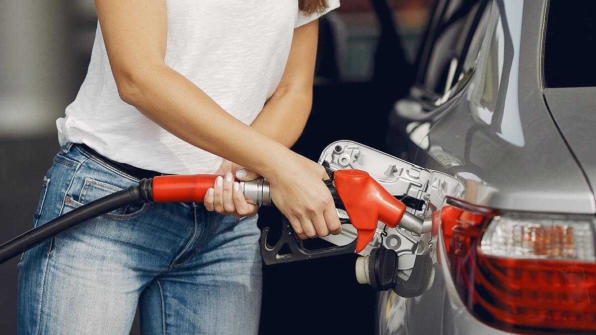 Una mujer reposta en una gasolinera.