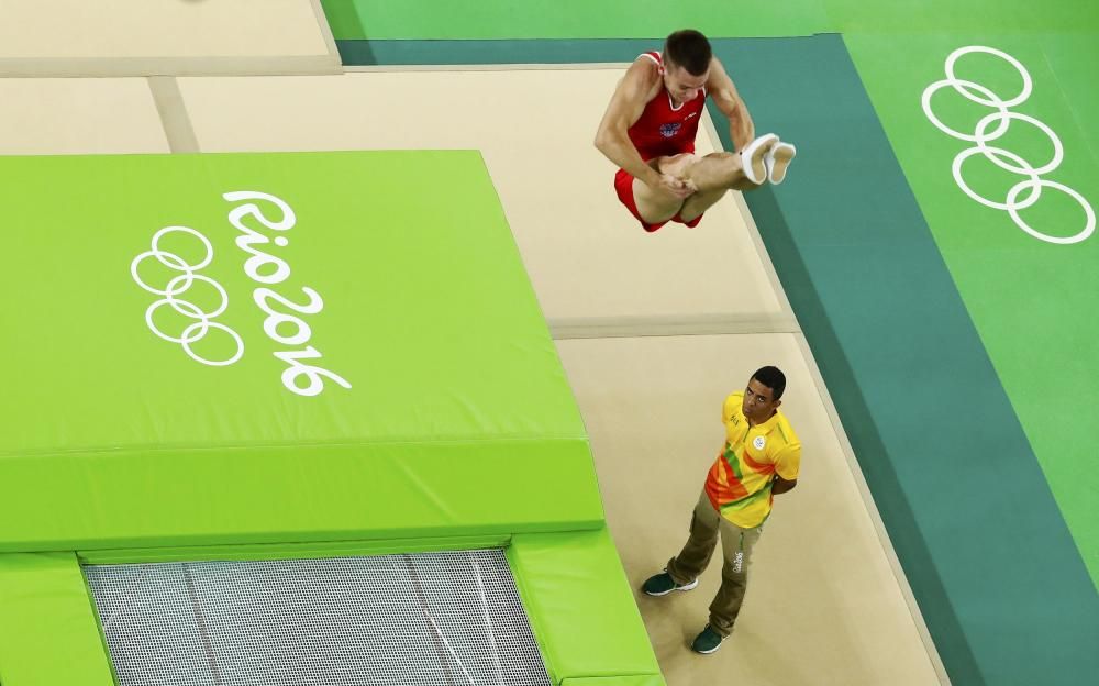 El gimnasta ruso Andrey Yudin ejercita ante la atenta mirada de un juez.