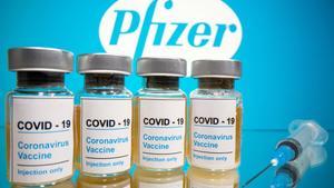 FILE PHOTO: Vials with a sticker reading, COVID-19 / Coronavirus vaccine / Injection only and a medical syringe are seen in front of a displayed Pfizer logo in this illustration taken October 31, 2020. REUTERS/Dado Ruvic/Illustration/File Photo