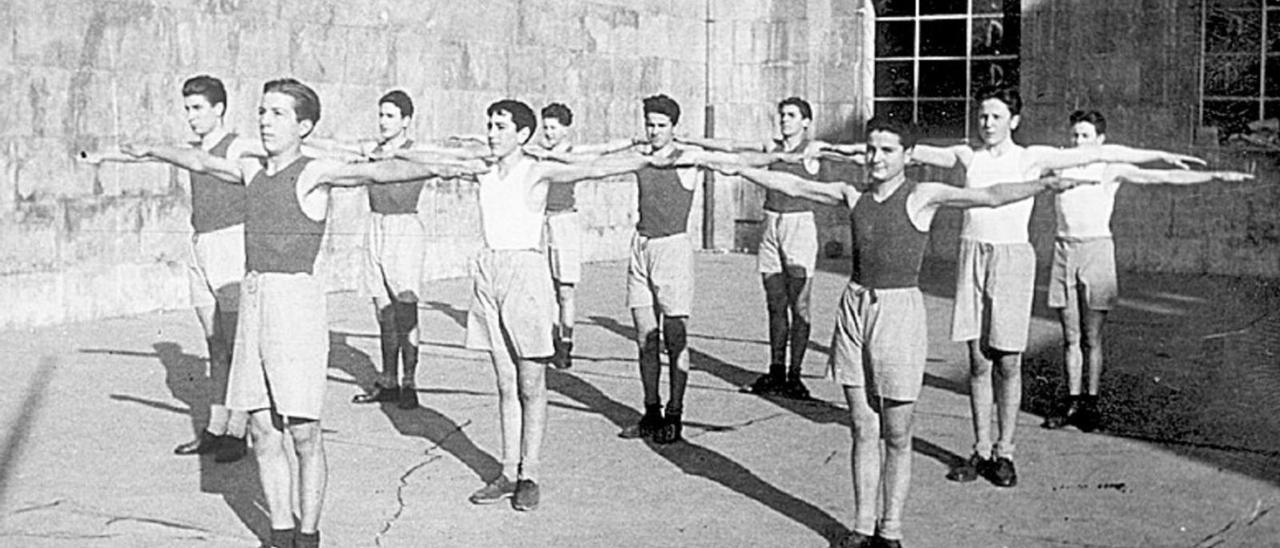 Alumnos del Instituto Alfonso II hacen ejercicio en el patio en una imagen tomada en los años cuarenta. | LNE