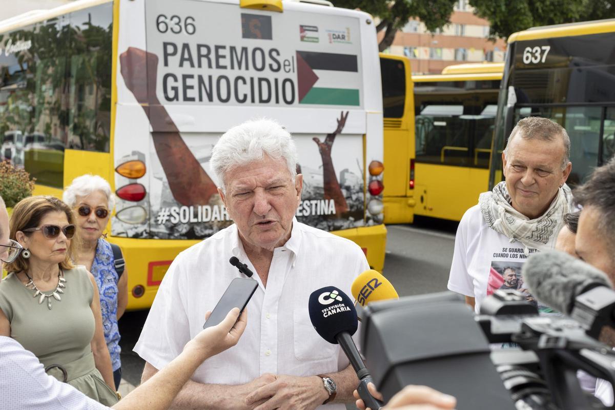 Pedro Quevedo junto a una guagua serigrafiada con motivo de una campaña en solidaridad con Palestina.