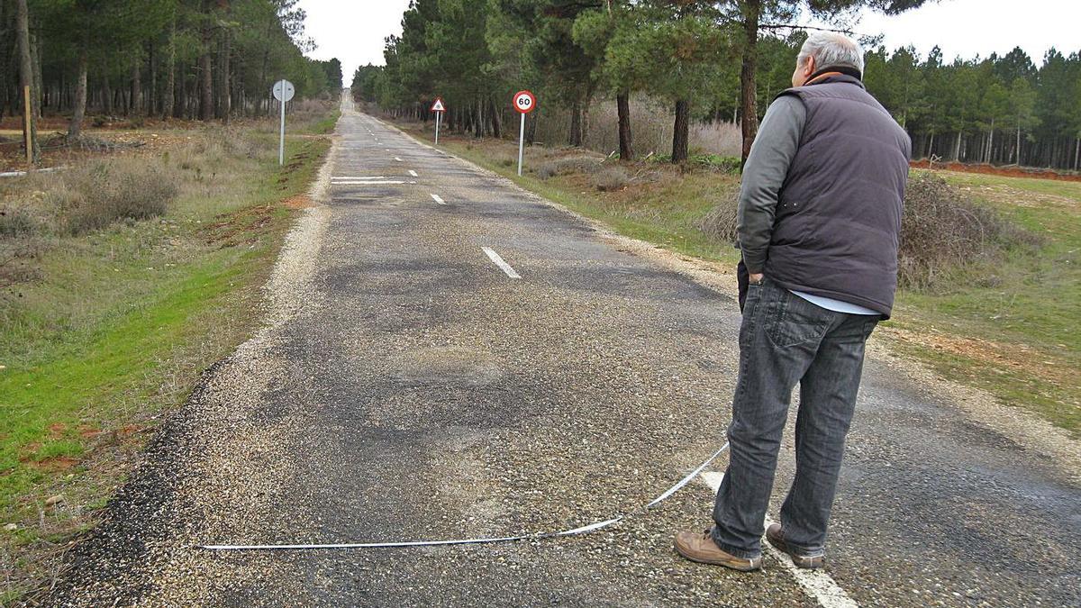 Un hombre midiendo la plataforma de la carretera de Alcubilla en una imagen de archivo. | L. O. Z.