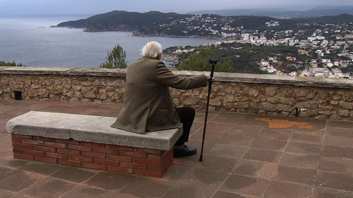 Un jubilado contempla el mar desde un pueblo de la Costa Brava.