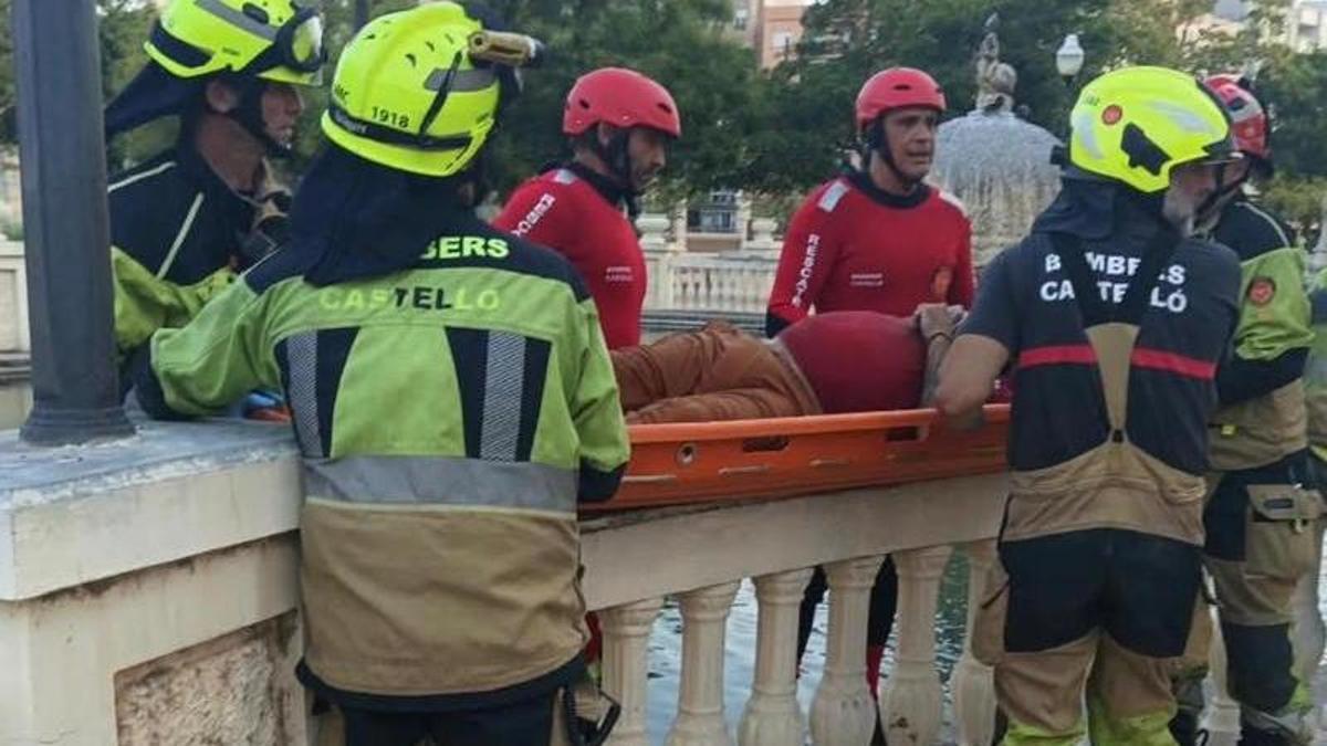 Los bomberos del Ayuntamiento de Castelló, sacando el cuerpo del estanque ayer en el Parque Ribalta.