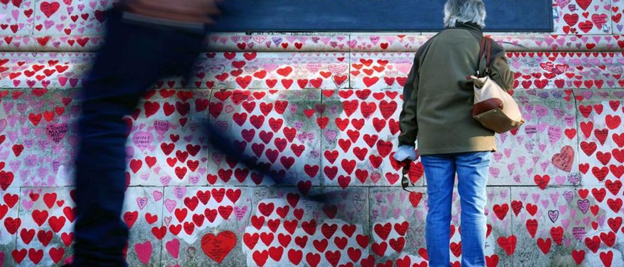 Una mujer ante un memorial del COVID en Londres.