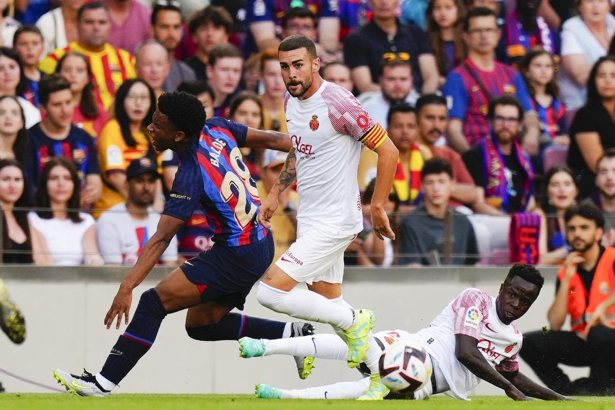 BARCELONA, 28/05/2023.- El defensa del FC Barcelona,Alejandro Balde (i) cae al suelo tras la entrada de Amath Ndiaye (d), delantero senegalés del Mallorca durante el encuentro correspondiente a la jornada 37 de primera división que disputan hoy domingo FC Barcelona y Mallorca en el estadio del Camp Nou, en Barcelona. EFE/ Enric Fontcuberta