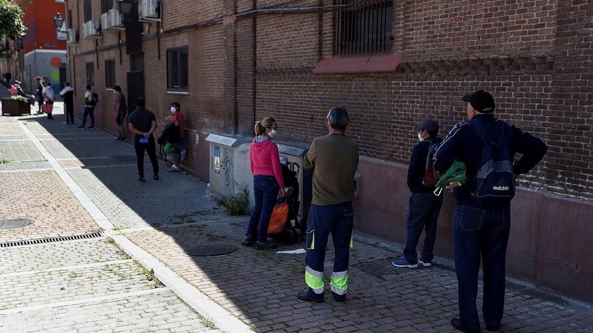 Cola para recoger alimentos en el comedor social de la parroquia de San Ramón Nonato, en Puente de Vallecas