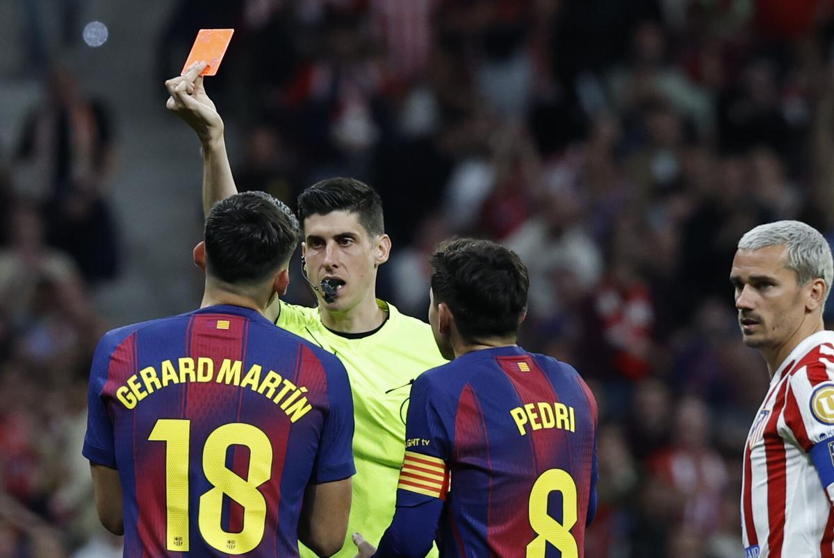 MADRID, 04/04/2026.- El árbitro del encuentro Mateo Busquets Ferre (2i) saca tarjeta roja a Gerard Martín del Barcelona que luego ha anulado tras revisar el VAR durante el partido de la jornada 30 de LaLiga EA Sports que Atlético de Madrid y FC Barcelona disputan este sábado, en el Estadio Riyadh Air Metropolitano de la capital española. EFE/ Chema Moya