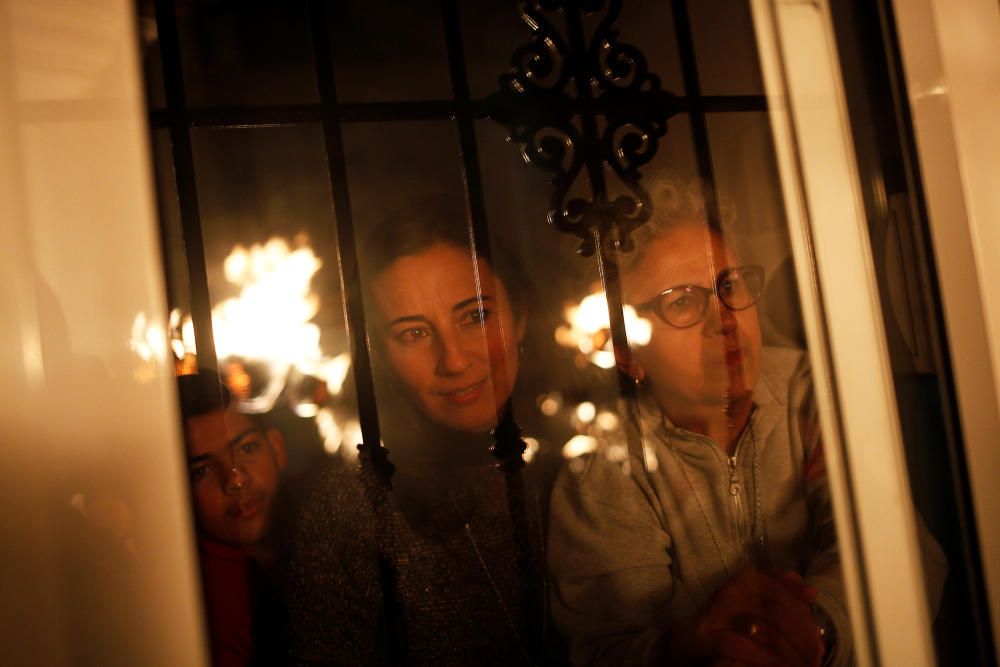 People watch from their house as villagers hold ...