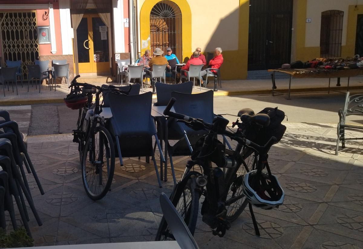 Los excursionistas en bici recuperan fuerzas en la terraza de un bar de Alcalalí
