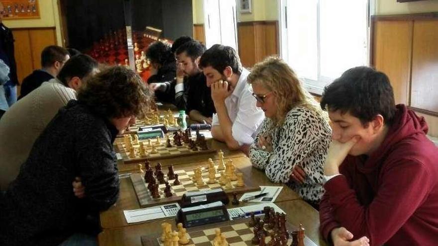 Los jugadores del Xadrez Ourense (d.), frente al tablero. // FdV