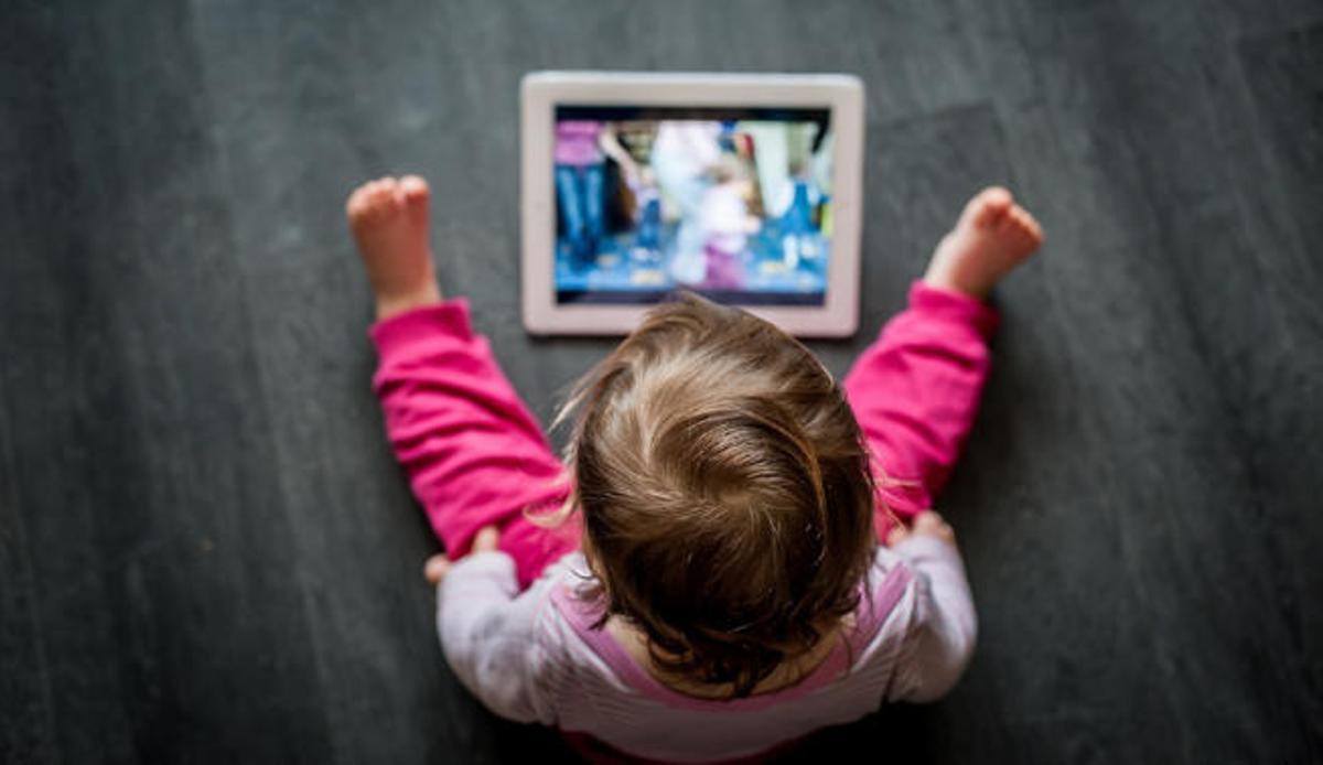 Un niño de corta edad frente a una pantalla.