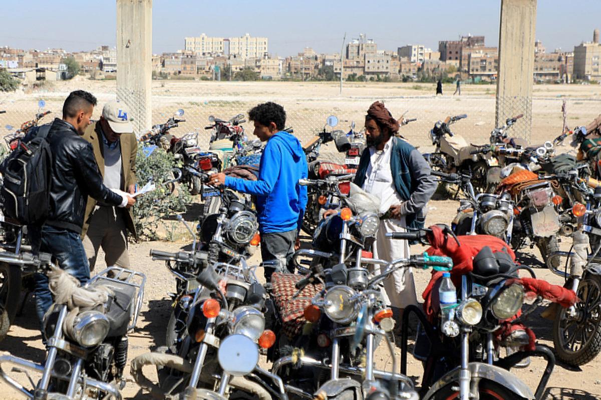 Los yemeníes se reúnen en medio de motocicletas mientras esperan que se les expidan licencias para conducir como parte de una campaña de seguridad de las autoridades huzíes, en Yemen