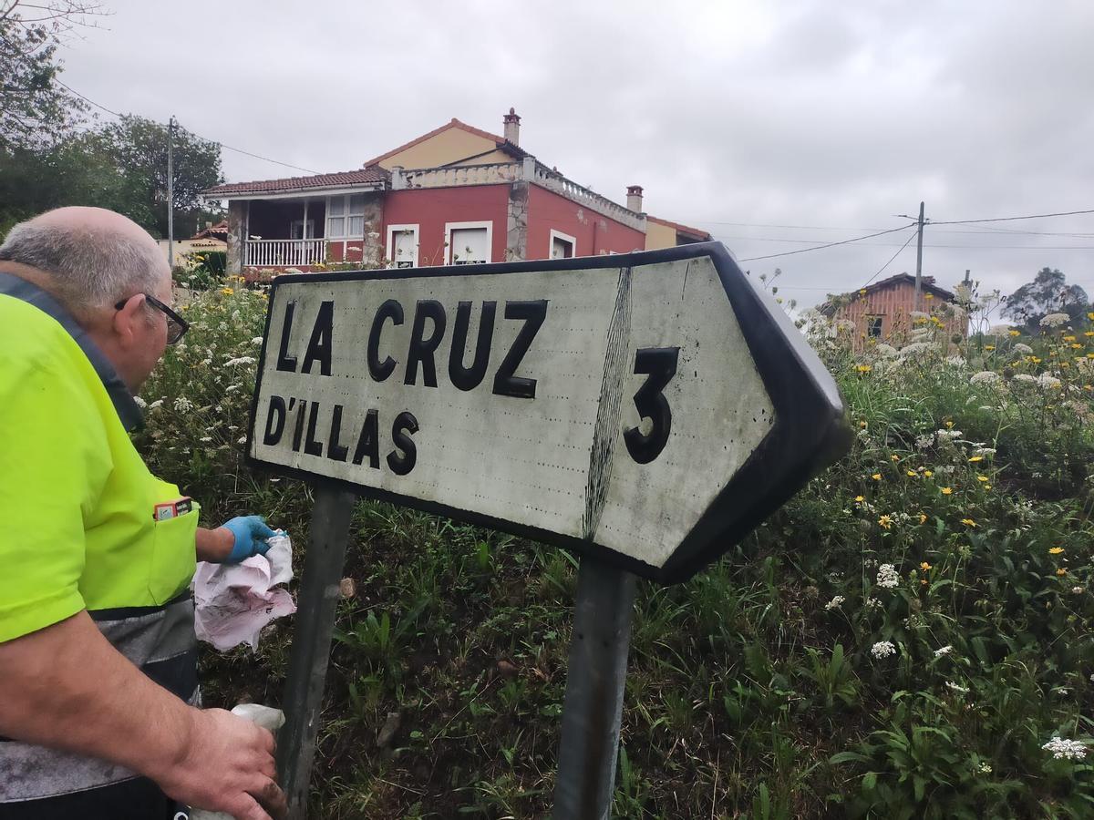 Un operario limpiando una señal vial en Castrillón en una imagen de archivo.