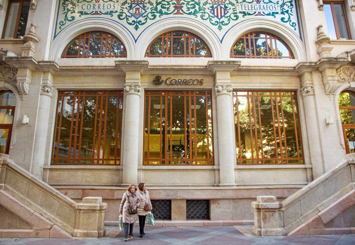 Dos mujeres salen del edificio de Correos en Alicante, minutos antes del cierre.