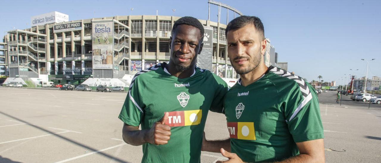 Yacine Qasmi y Nuke Mfulu, los dos futbolistas africanos del Elche, posan juntos con el Martínez Valero al fondo.