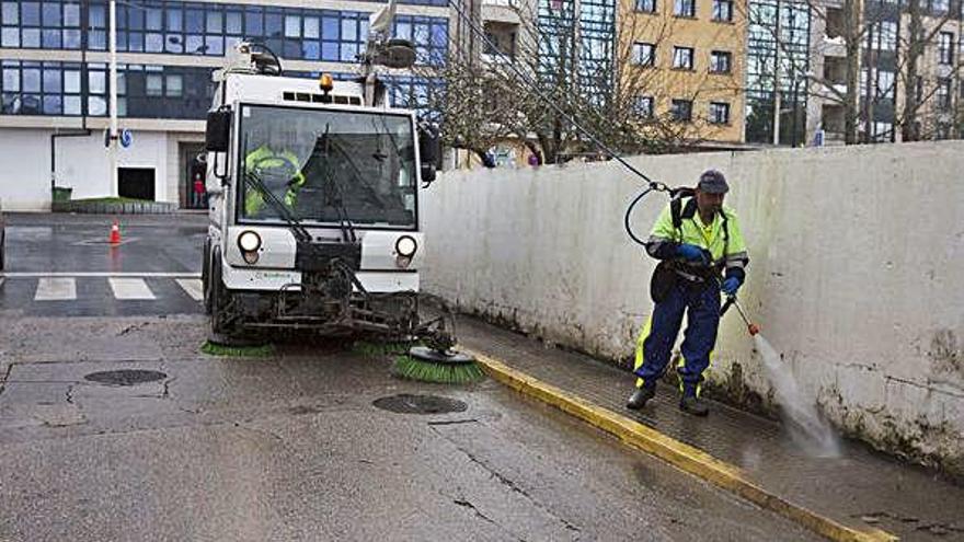 Operarios limpian una calle en el centro de Sada.