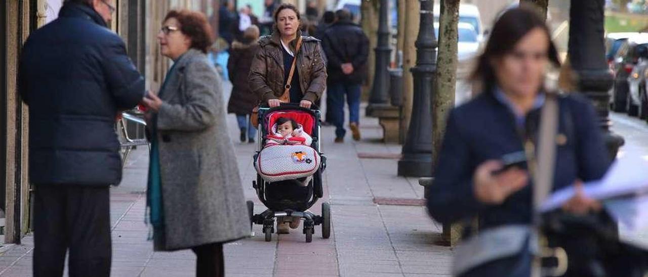 Una mujer pasea con una niña de corta edad por una calle de Lalín. // Bernabé/Gutier