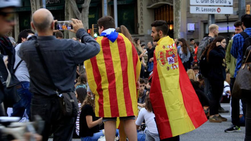 Un noi amb una bandera estelada i un altre amb una d&#039;espanyola en el marc d&#039;una concentració