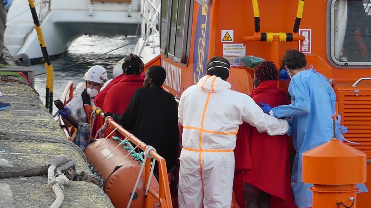 Archivo - Agentes de salvamento marítimo ayudan a un hombre migrante a desembarcar en Arguineguín (Gran Canaria)