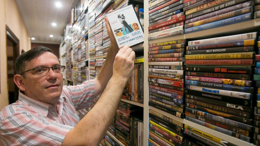 Juan Carlos Vizcaíno, con su película favorita en la mano, Dos en la carretera, de las 14.000 cintas que almacena en su casa.