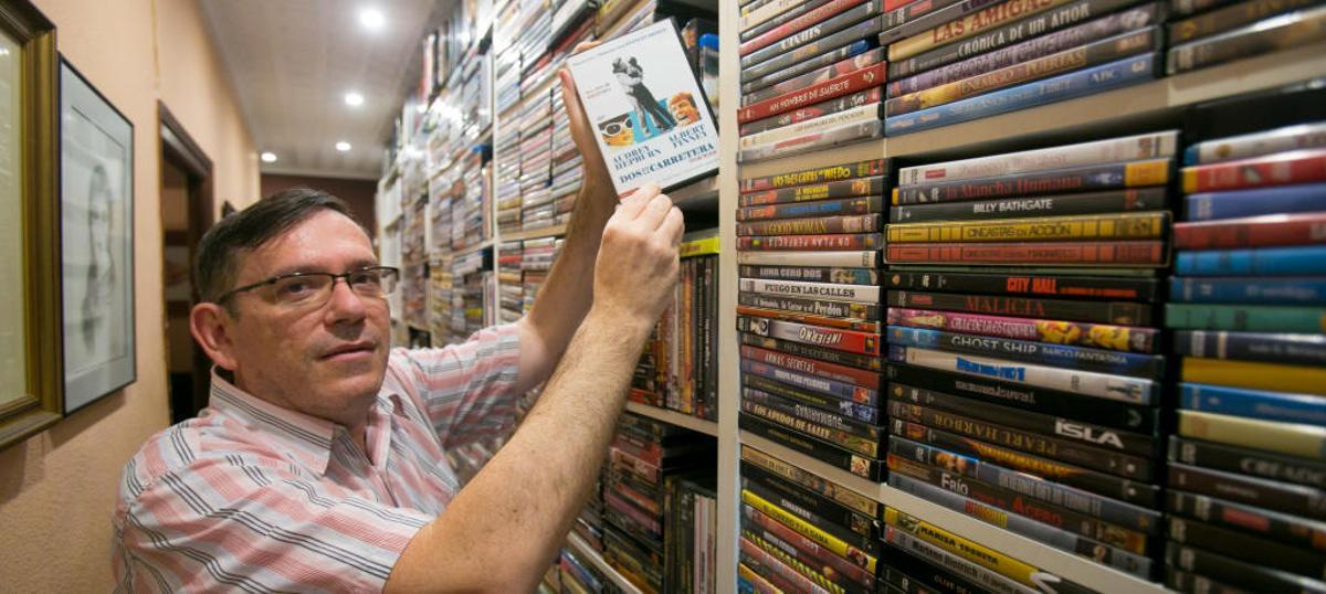 Juan Carlos Vizcaíno, con su película favorita en la mano, Dos en la carretera, de las 14.000 cintas que almacena en su casa.