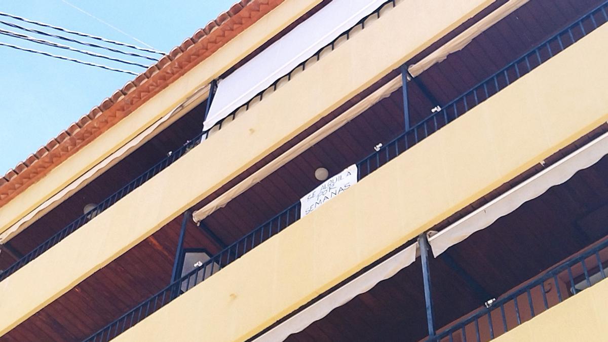 Cartel de alquiler por semanas en el balcón de un piso de un barrio residencial de Xàbia