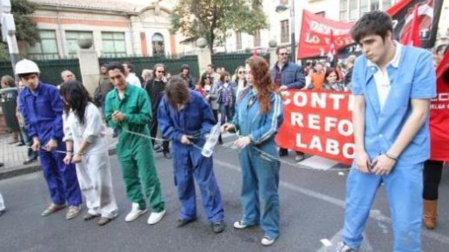 Un grupo de manifestantes simboliza las «ataduras» de la nueva reforma.