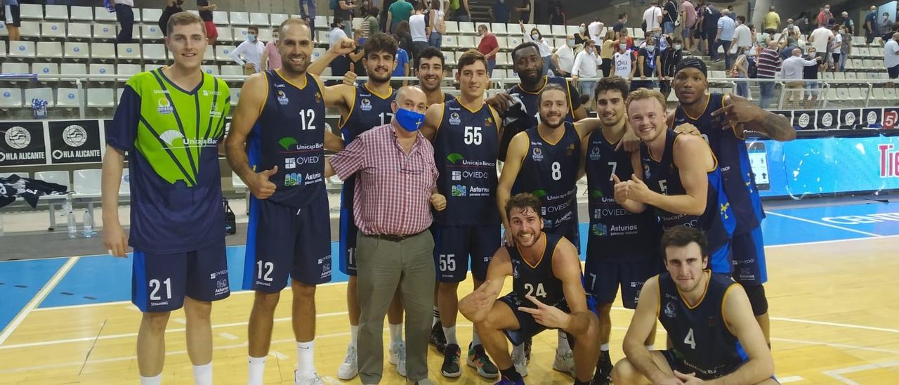 Los jugadores del Oviedo Baloncesto celebran con un aficionado su triunfo en la pista del Alicante