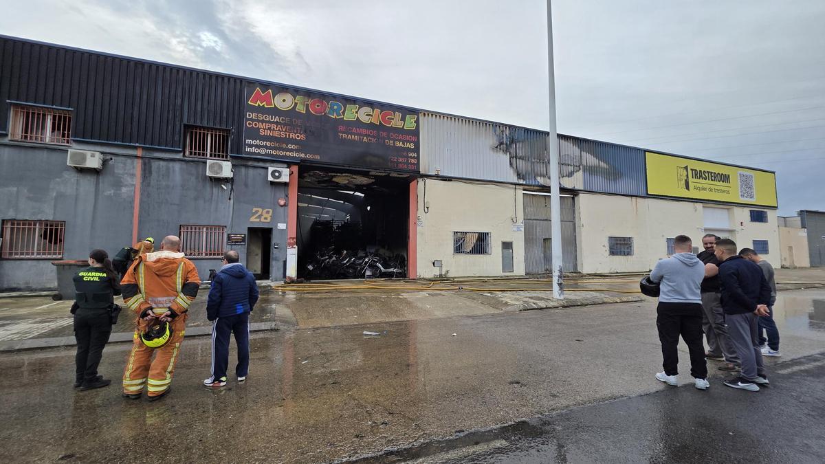 Los empleados contemplan la nave incendiada