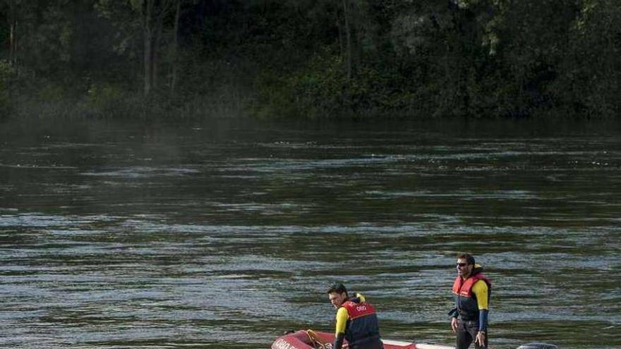 Los bomberos, rastreando ayer el cauce del Miño, a la altura de la zona termal de A Chavasqueira. // Brais