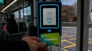 Un usuario valida la T-Mobilitat en el Tram, en Barcelona.