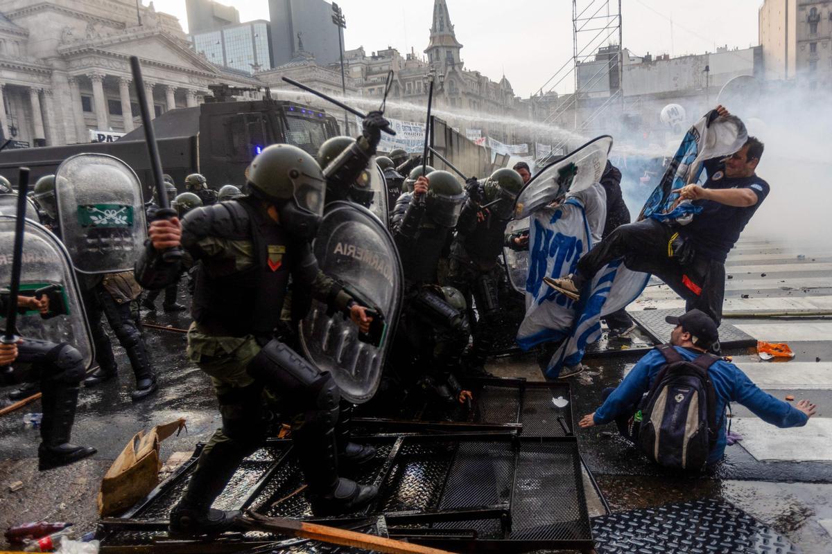 Manifestantes chocan con la policía antidisturbios frente al Congreso Nacional en Buenos Aires el 12 de junio de 2024. Los senadores argentinos debaten un paquete de reformas clave para el presidente ultraderechista Javier Milei, en una sesión marcada por huelgas y manifestaciones frente al Congreso.