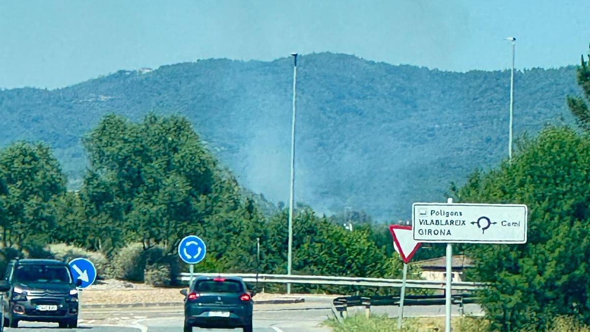 Columna de fum de l’incendi de vegetació a la Font de la Pólvora de Girona vista des de la carretera.