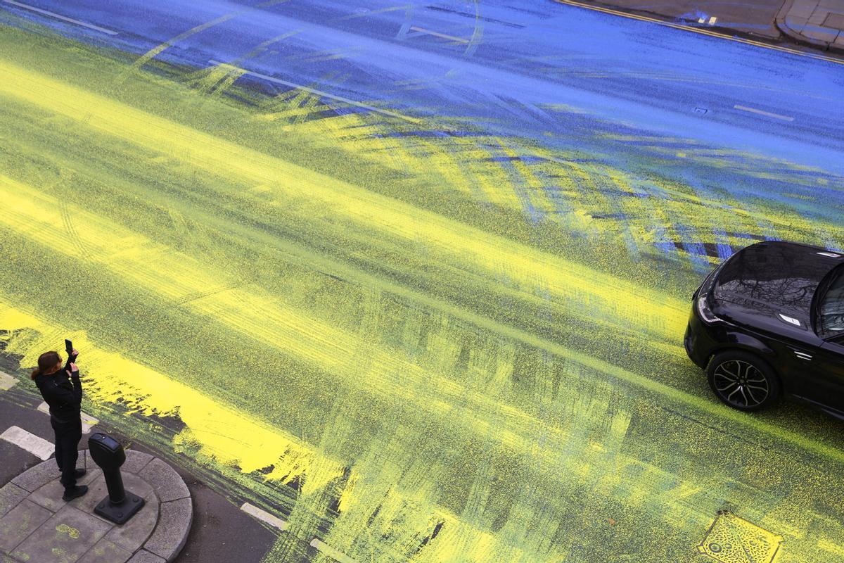 Activistas pintan la bandera de Ucrania frente a la embajada rusa en Londres