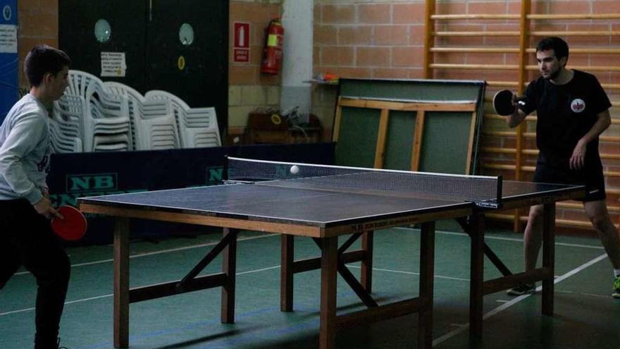 Dos jugadores pracican tenis de mesa en el Pabellón Social de San José Obrero.