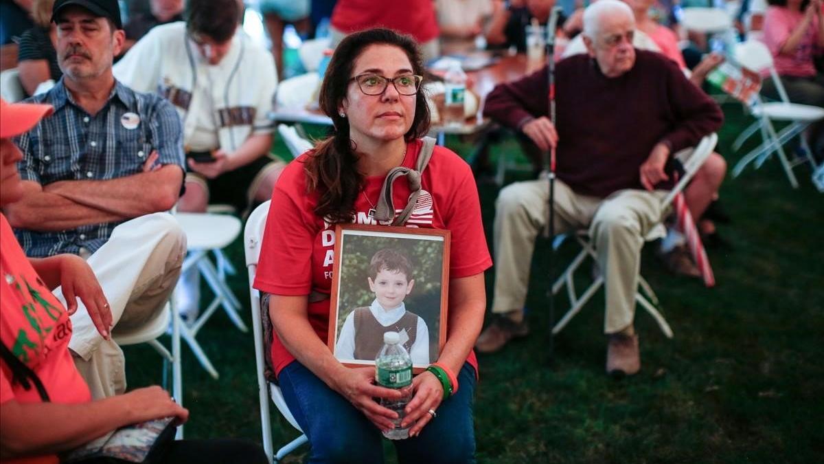 Una madre sostiene la foto de su hijo fallecido en la masacre.
