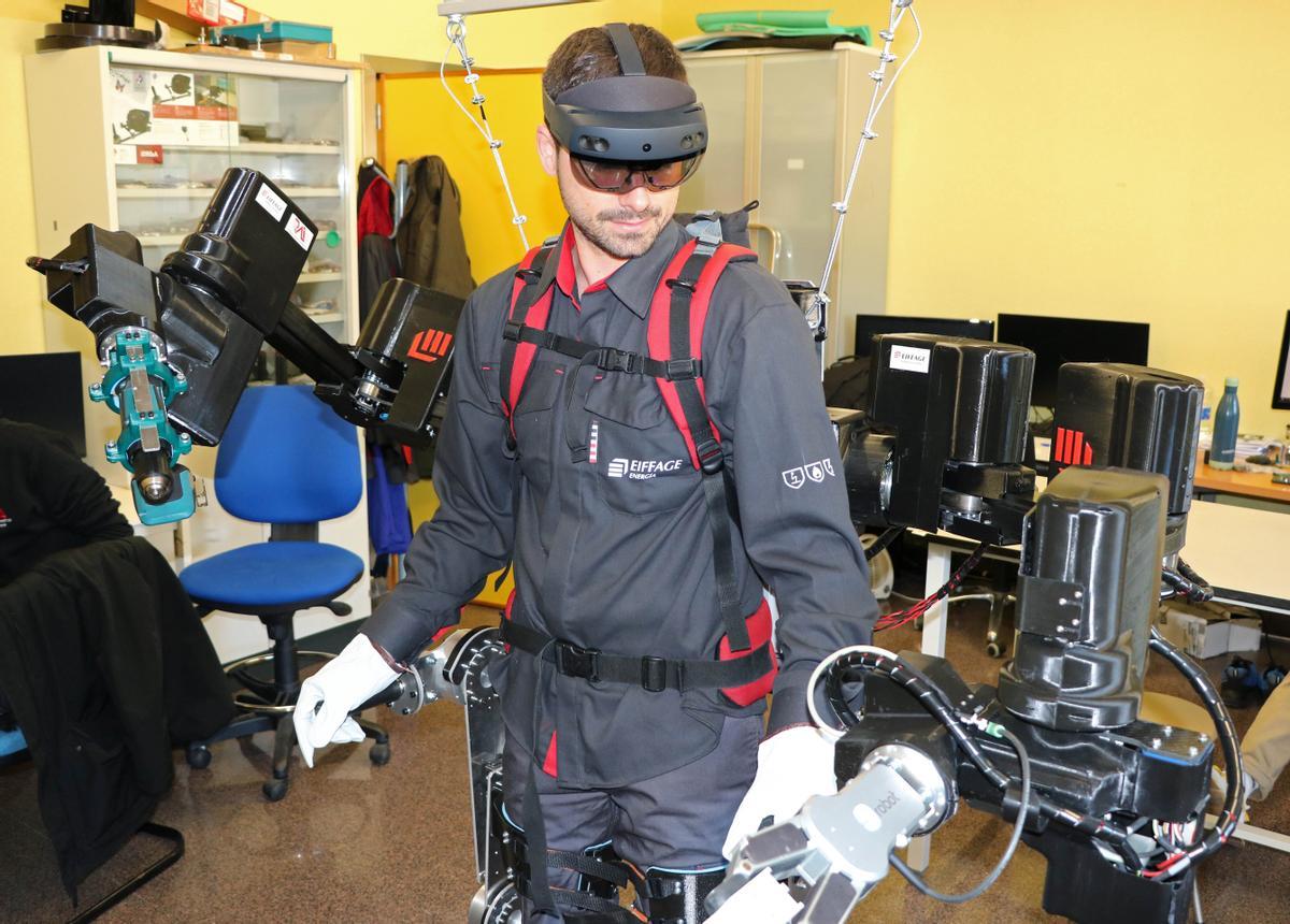 El sistema se compone de unos segundos brazos robóticos llevables, soportados por una estructura de tipo exoesqueleto para los miembros inferiores para ser empleado en el puesto de trabajo.