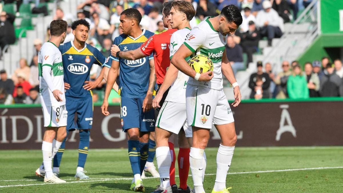 Mir se dispone a lanzar el penalti, con El Hilali recriminándole al fondo