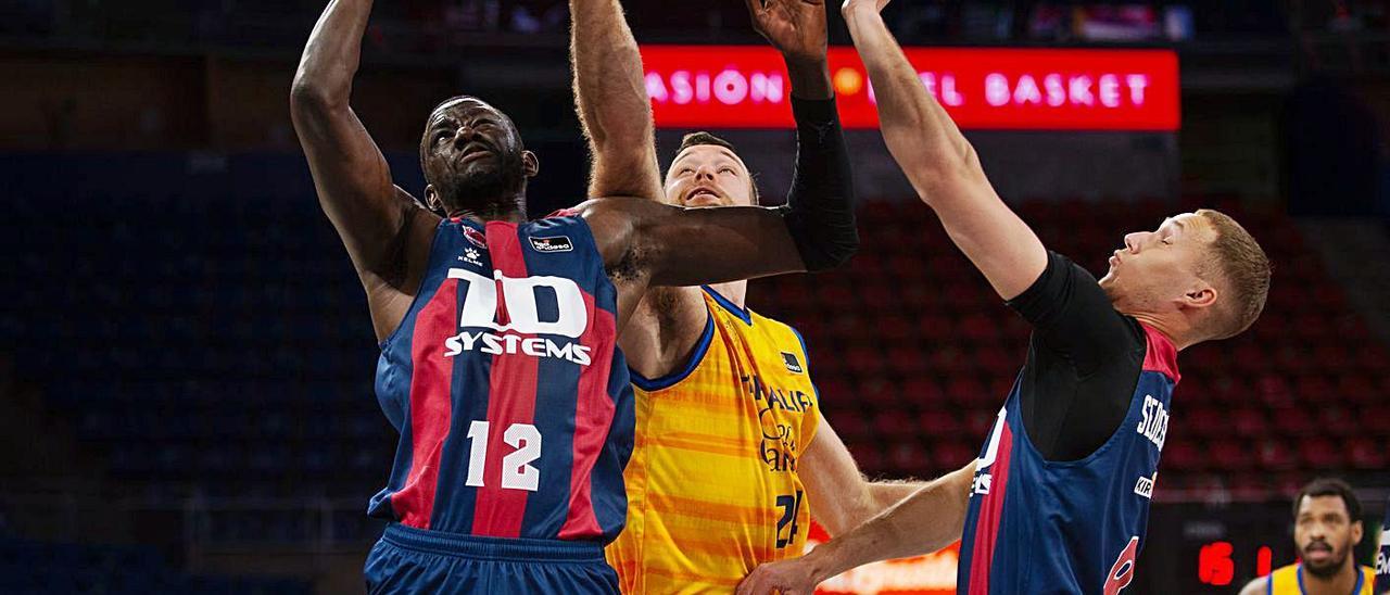 Ilimane Diop (12) captura un rebote ante Costello en el Baskonia-Gran Canaria de la pasada campaña en Vitoria. | | ACB PHOTO/A. BOUZO