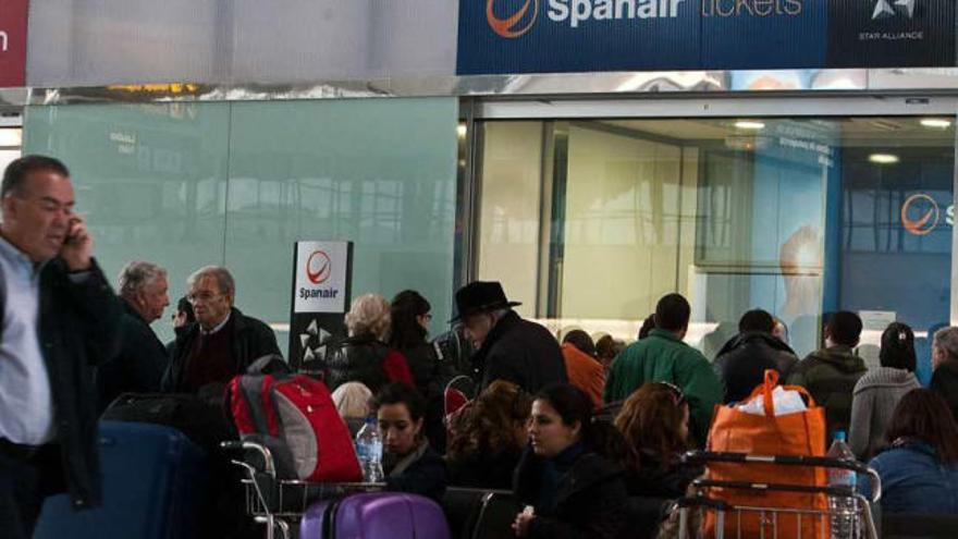 Afectados por el cierre de Spanair hacen cola ante el mostrador de la compañía en el        aeropuerto de El Altet.