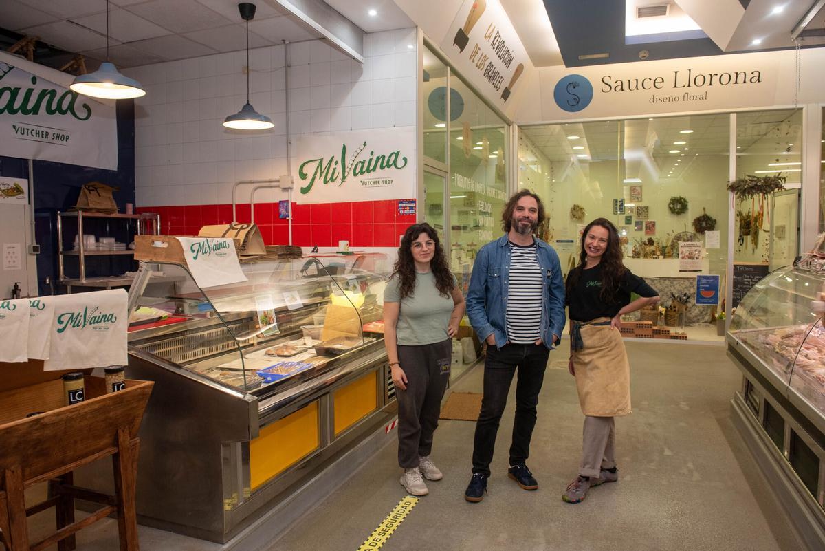 Clara Armesto, Dani Rocha y Carolina Rodríguez delante de sus puestos en el mercado de Elviña