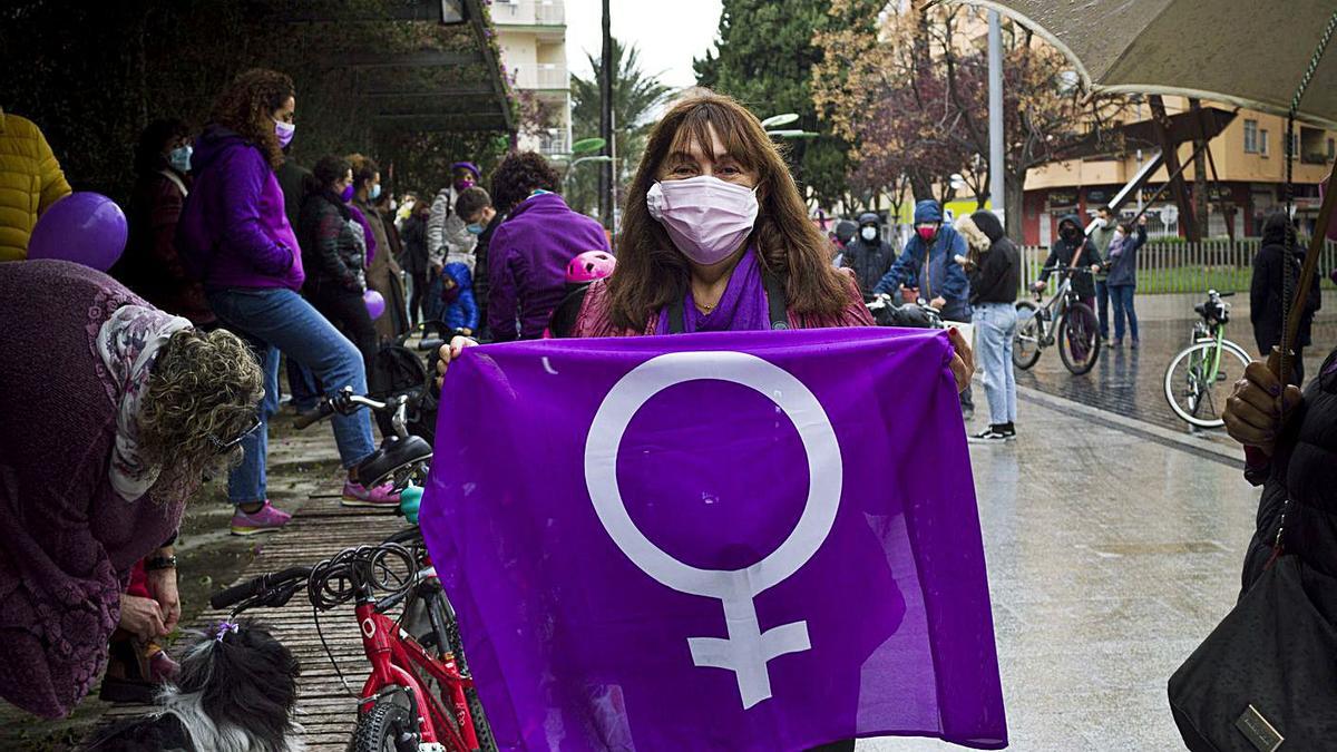 Una de las participantes en la marcha ciclistas de Gandia, justo antes de partir. A la derecha, el artista Toni Espinar durante la reparación del mural feminista atacado.                     | DANI MONLLOR